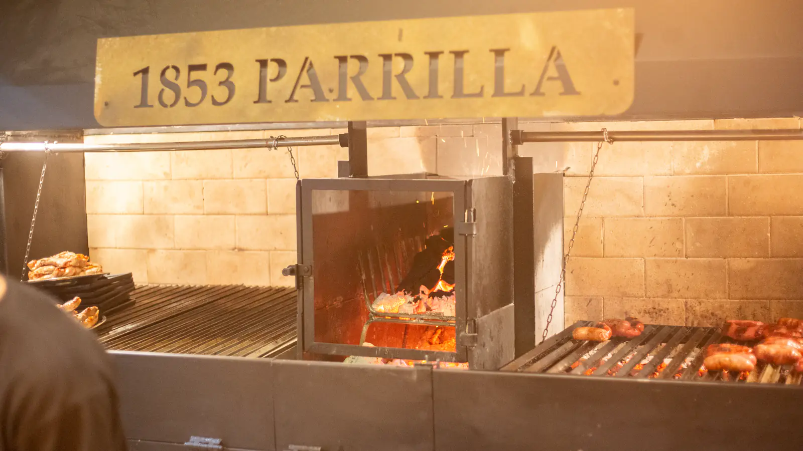 El fuego de la parrilla 1853 con cortes y achuras sobre las brasas