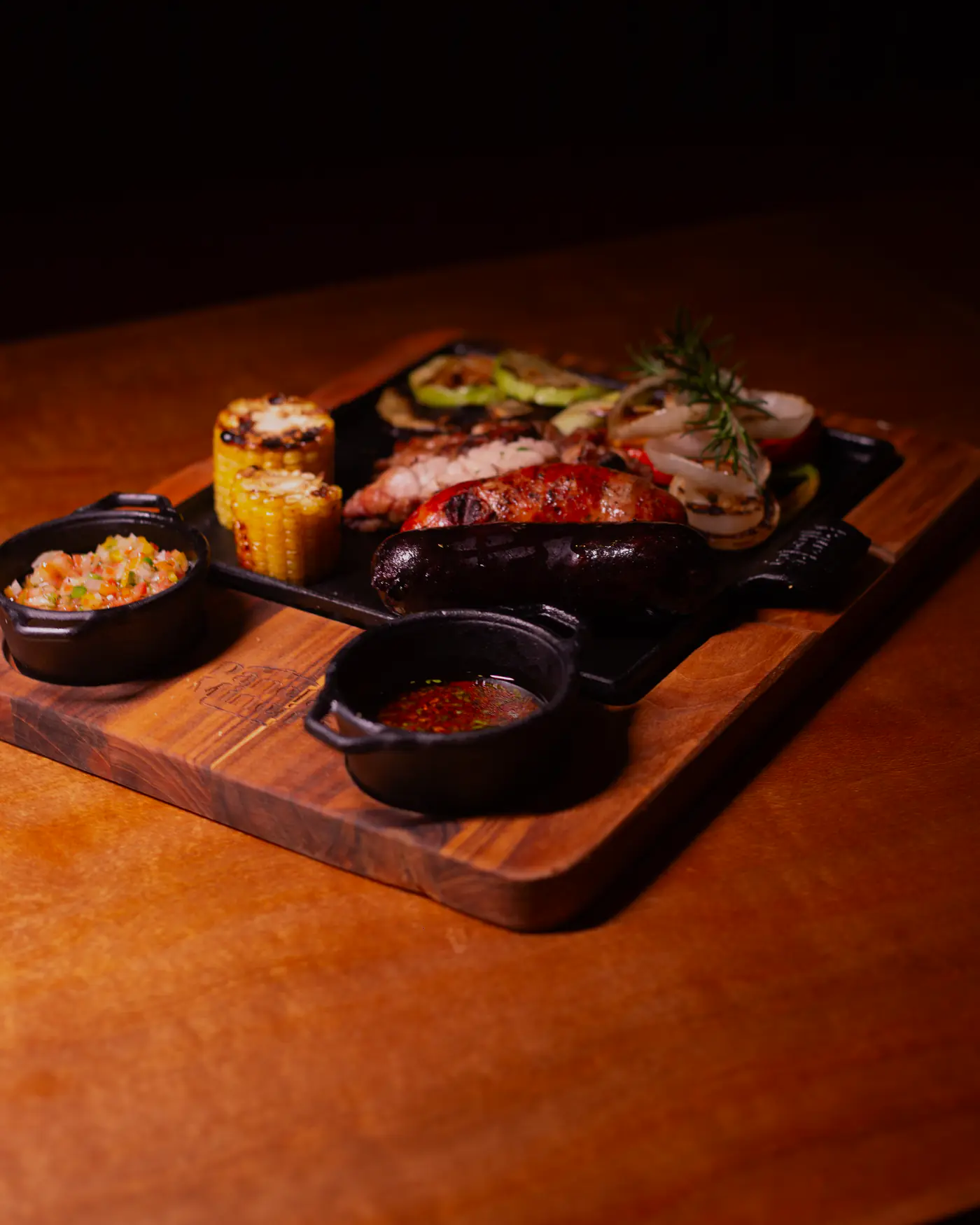 Parrillada para compartir: chorizo, morcilla, choclo y verduras asadas con salsas